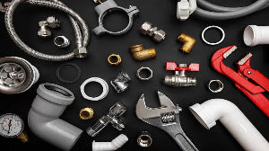 Collection of plumbing tools and parts on a black background