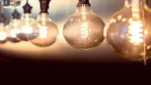 Three vintage-style light bulbs hanging against a dark background